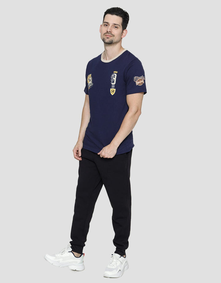 T Zone Badge Print Varsity Kaos Pria